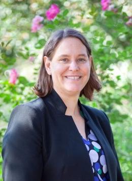 Woman with polka dot dress and black blazer smiling